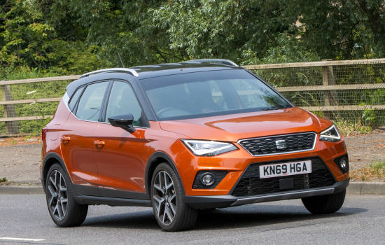 orange seat arona driving on road