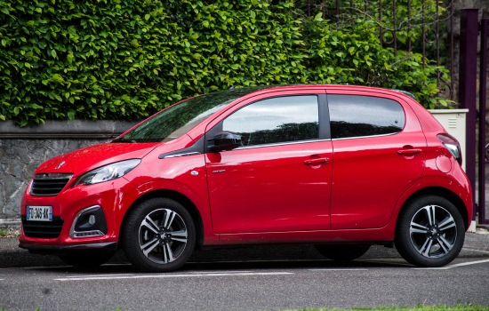 red peugeot 108 parked on road