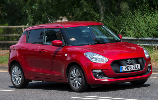 red suzuki swift driving