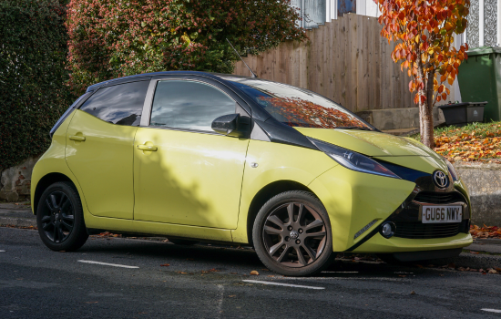 yellow toyota aygo parked on road