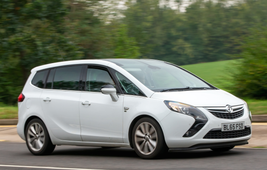 white vauxhall zafira driving on road