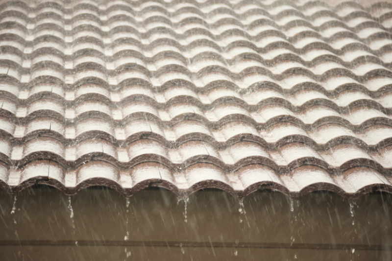 heavy rain falling on roof of house