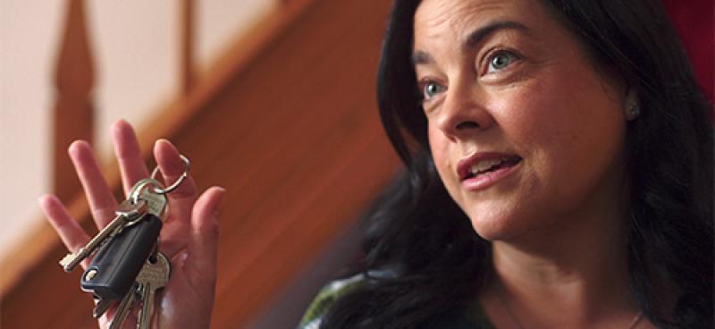 Middle aged woman holding car keys for young driver son