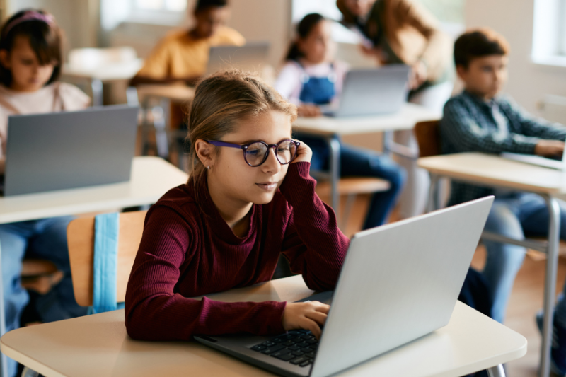 girl in classroom looking at laptop